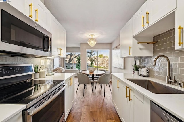 kitchen featuring white cabinetry, stainless steel appliances, sink, and decorative backsplash