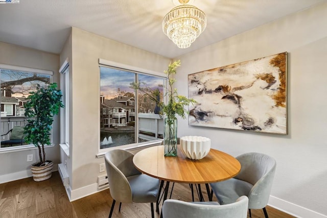 dining room with hardwood / wood-style flooring and a notable chandelier