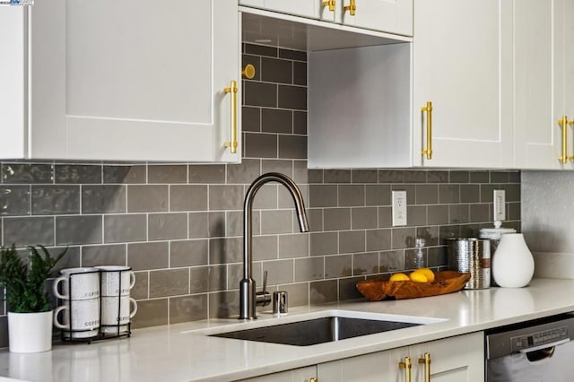 kitchen featuring tasteful backsplash, dishwasher, sink, and white cabinets