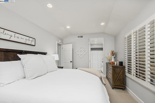 bedroom featuring light colored carpet and vaulted ceiling