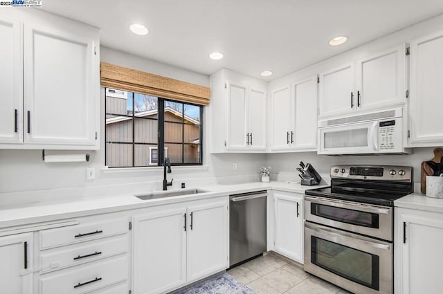 kitchen featuring white cabinetry, sink, stainless steel appliances, and light tile patterned flooring