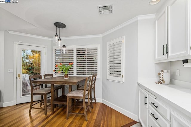 dining room with hardwood / wood-style floors and ornamental molding