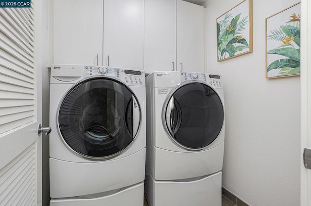 washroom with cabinets and washing machine and dryer