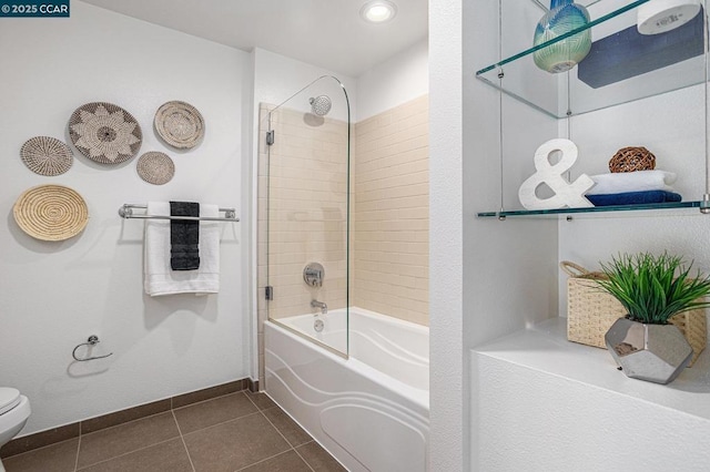 bathroom with tile patterned floors, toilet, and tiled shower / bath