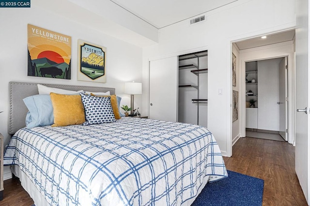 bedroom with dark wood-type flooring and a closet