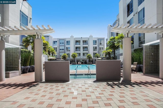 view of patio featuring a community pool and a pergola