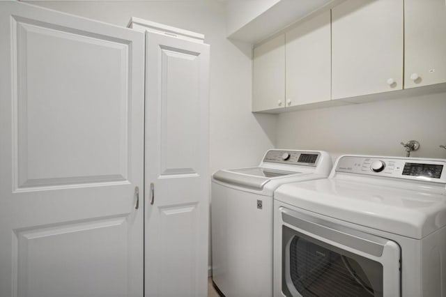 laundry area with cabinets and washing machine and clothes dryer