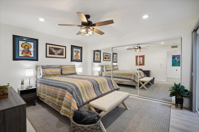 bedroom with light hardwood / wood-style floors, a closet, and ceiling fan