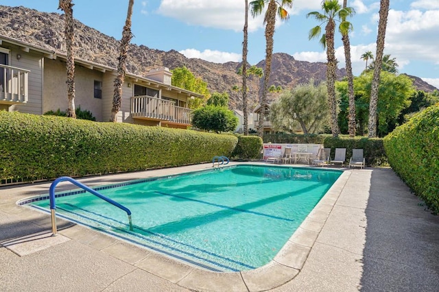 view of swimming pool with a mountain view and a patio