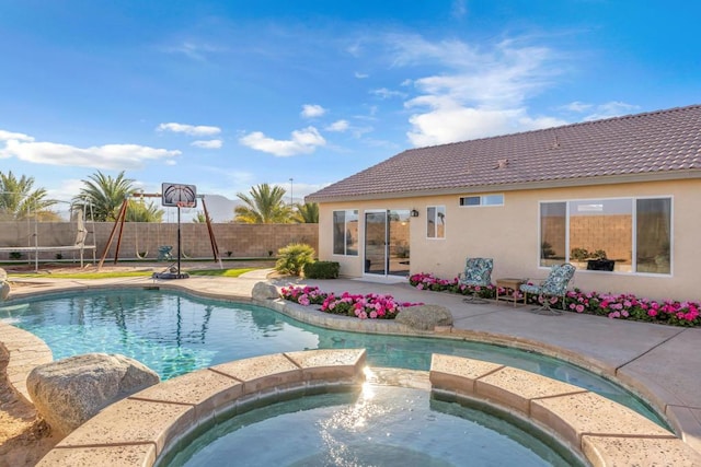 view of swimming pool featuring an in ground hot tub, a trampoline, and a patio