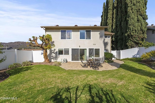 rear view of property featuring a patio and a lawn