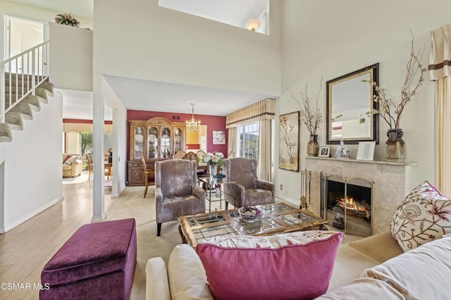 living room with a chandelier, light hardwood / wood-style flooring, and a high ceiling