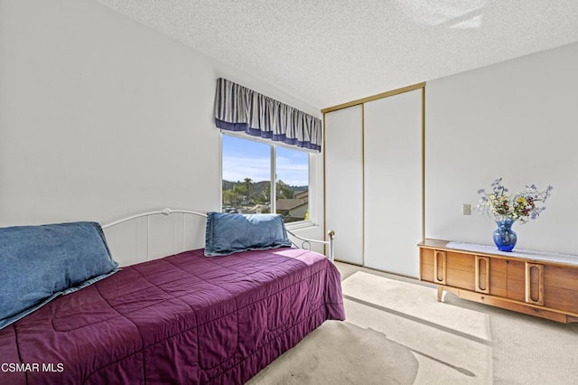 bedroom featuring a closet, a textured ceiling, and carpet