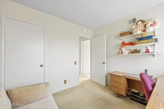 carpeted office space featuring a textured ceiling