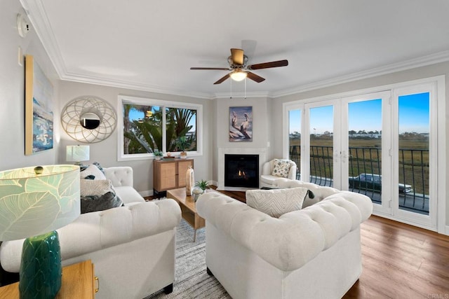 living room featuring hardwood / wood-style flooring, ceiling fan, crown molding, and french doors