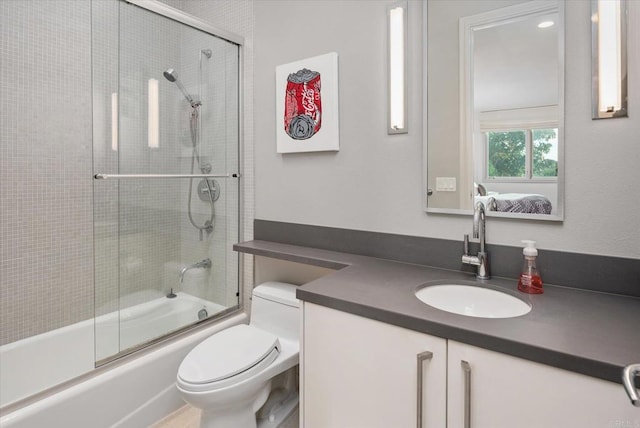 full bathroom featuring shower / bath combination with glass door, vanity, and toilet