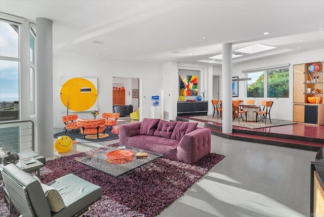 living room featuring a skylight and concrete floors