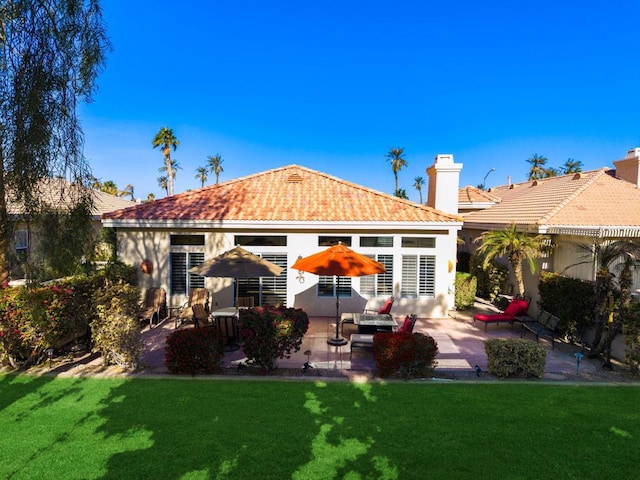 rear view of house featuring a patio and a yard