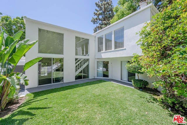 rear view of house featuring a yard