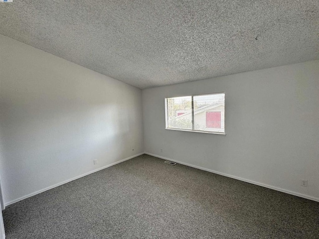 carpeted spare room featuring a textured ceiling