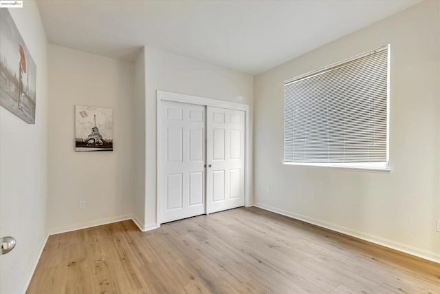 unfurnished bedroom with a closet and light hardwood / wood-style flooring