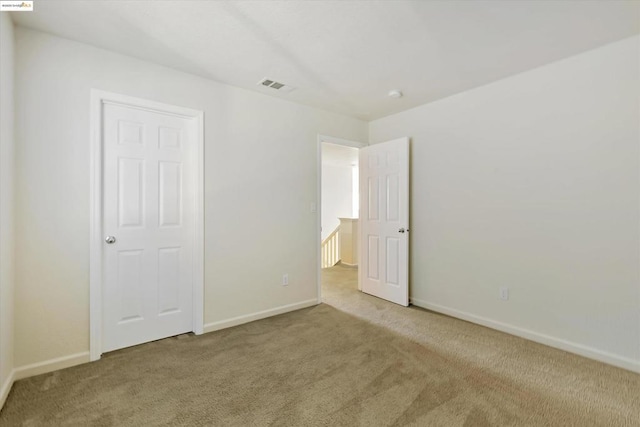 unfurnished bedroom featuring light carpet