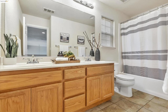 full bathroom featuring tile patterned floors, toilet, vanity, and shower / bath combo