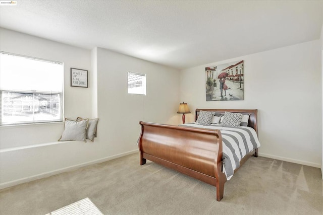 bedroom with multiple windows and light colored carpet