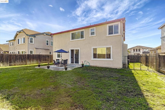 back of property with a patio area and a lawn