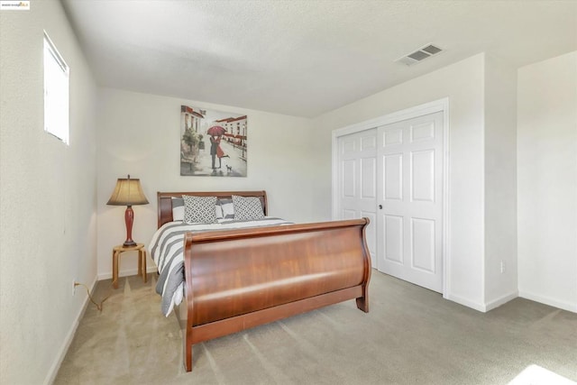 bedroom with light carpet and a closet