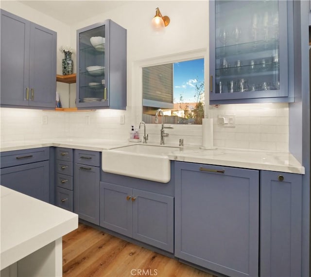 kitchen with hardwood / wood-style floors, decorative backsplash, and sink