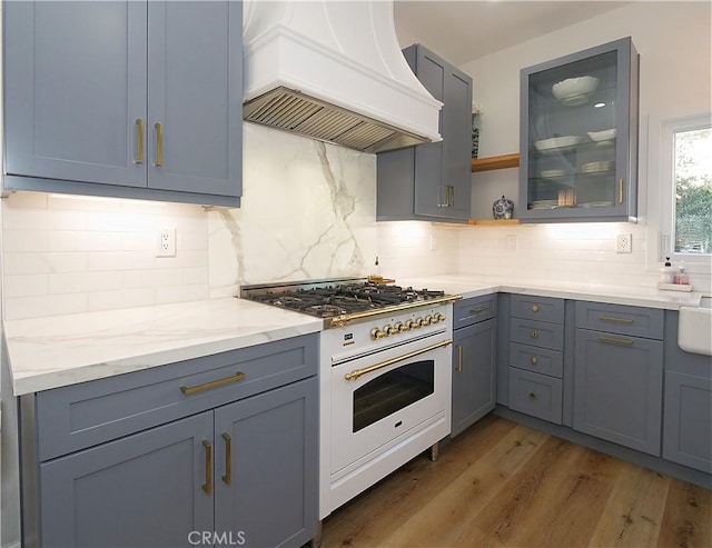 kitchen with dark hardwood / wood-style flooring, white range oven, custom exhaust hood, and gray cabinetry