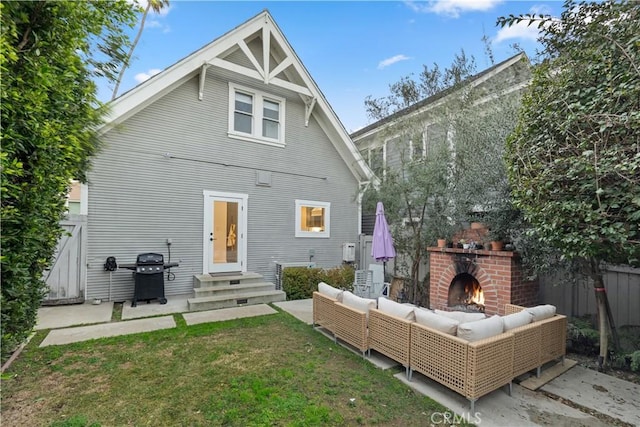 back of house with a lawn, a patio, and an outdoor living space with a fireplace