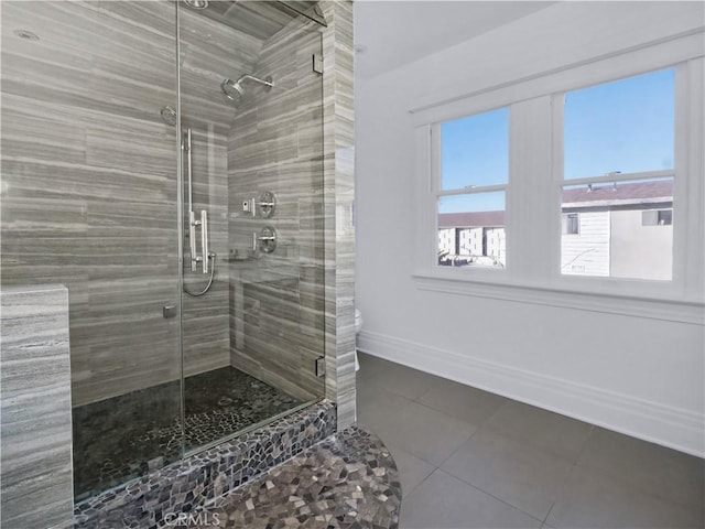 bathroom featuring a shower with door, tile patterned floors, and toilet