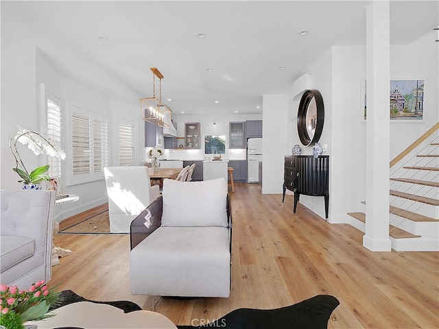 living room with light hardwood / wood-style flooring and a chandelier