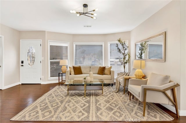 living room featuring dark wood-type flooring and a chandelier