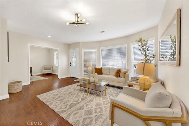 living room featuring an inviting chandelier and dark hardwood / wood-style floors