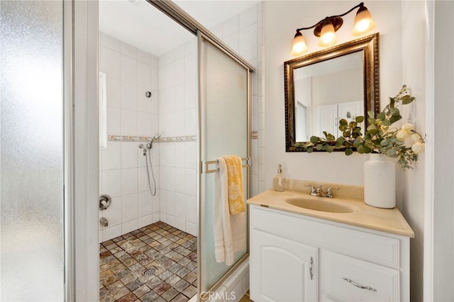 bathroom with vanity and a shower with door