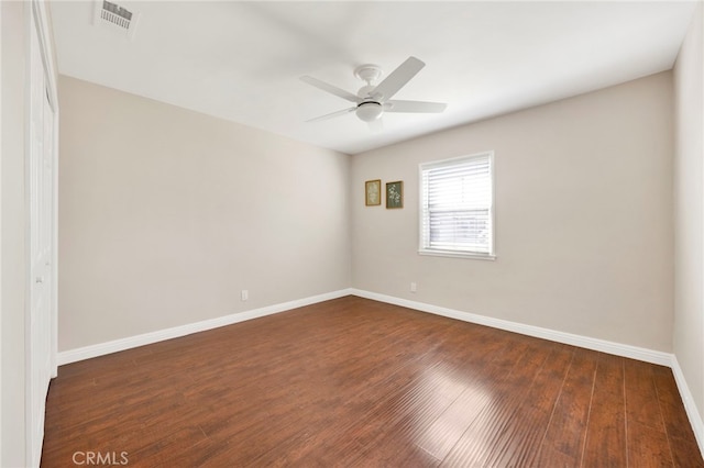 empty room with dark wood-type flooring and ceiling fan