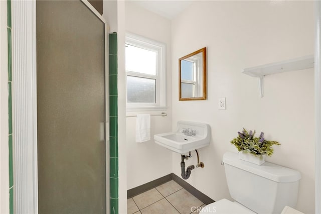 bathroom featuring tile patterned flooring, a shower with shower door, and toilet