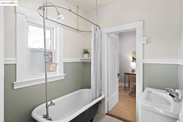 bathroom featuring wood-type flooring, sink, and shower / bath combo