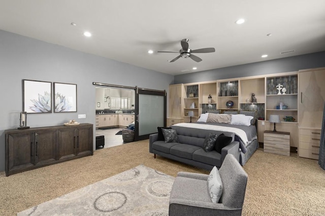 bedroom featuring ceiling fan, sink, and light carpet