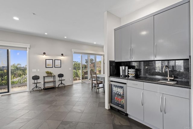 kitchen featuring wine cooler, sink, tasteful backsplash, and a wealth of natural light