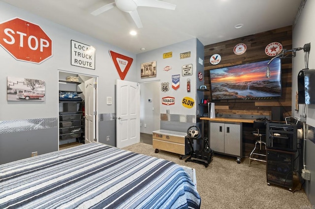 carpeted bedroom with wooden walls and ceiling fan