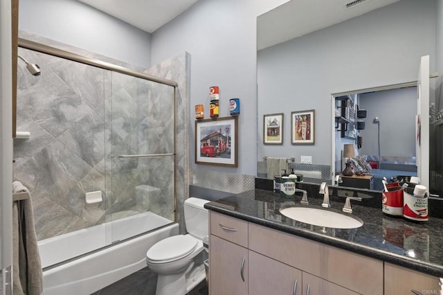 full bathroom with vanity, combined bath / shower with glass door, and toilet