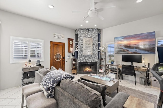 living room featuring light tile patterned flooring, ceiling fan, and a tiled fireplace