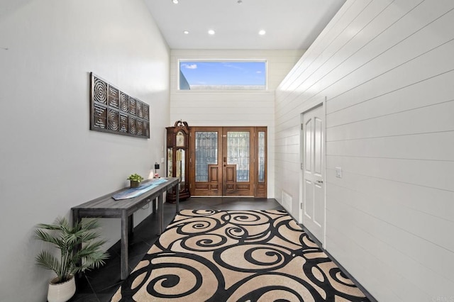 tiled foyer entrance featuring french doors and a towering ceiling