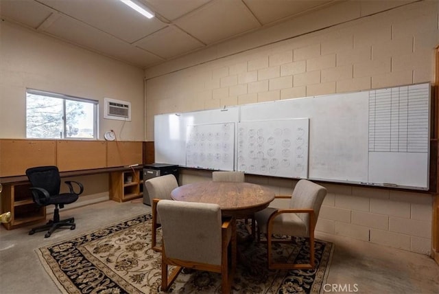 dining room with a wall unit AC and concrete floors