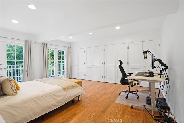 bedroom with multiple closets, access to exterior, light hardwood / wood-style floors, and french doors