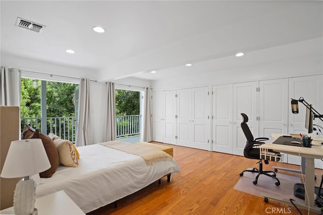 bedroom with access to outside, multiple closets, and light wood-type flooring